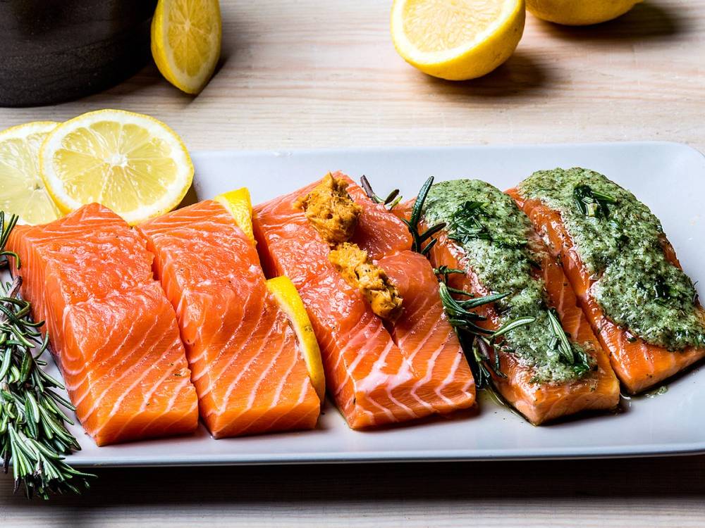 Laksebiter med sitron og urter på en hvit tallerken, klar til servering.