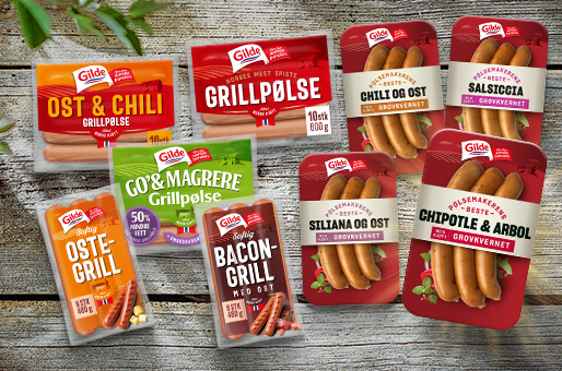 Ulike pakker med Gilde pølser, inkludert grillpølser med ost og chili, bacon-grillpølser, og salami, lagt ut på en treoverflate.