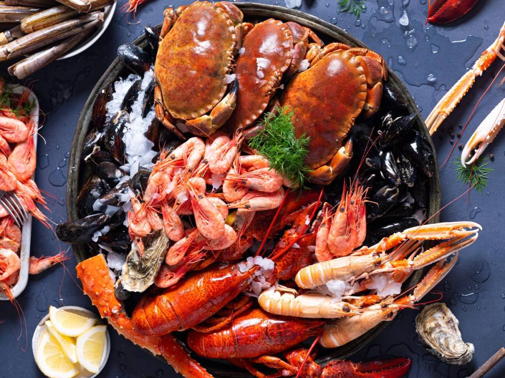 Et fat med ulike skalldyr som hummer, reker og krabbe, klar for helgekos.