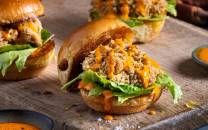 Krabbesliders med brioche hamburgerbrød, salat og saus på en treplate.