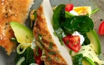 Kyllingfilet i focacciabrød med salat og cherrytomater på en tallerken