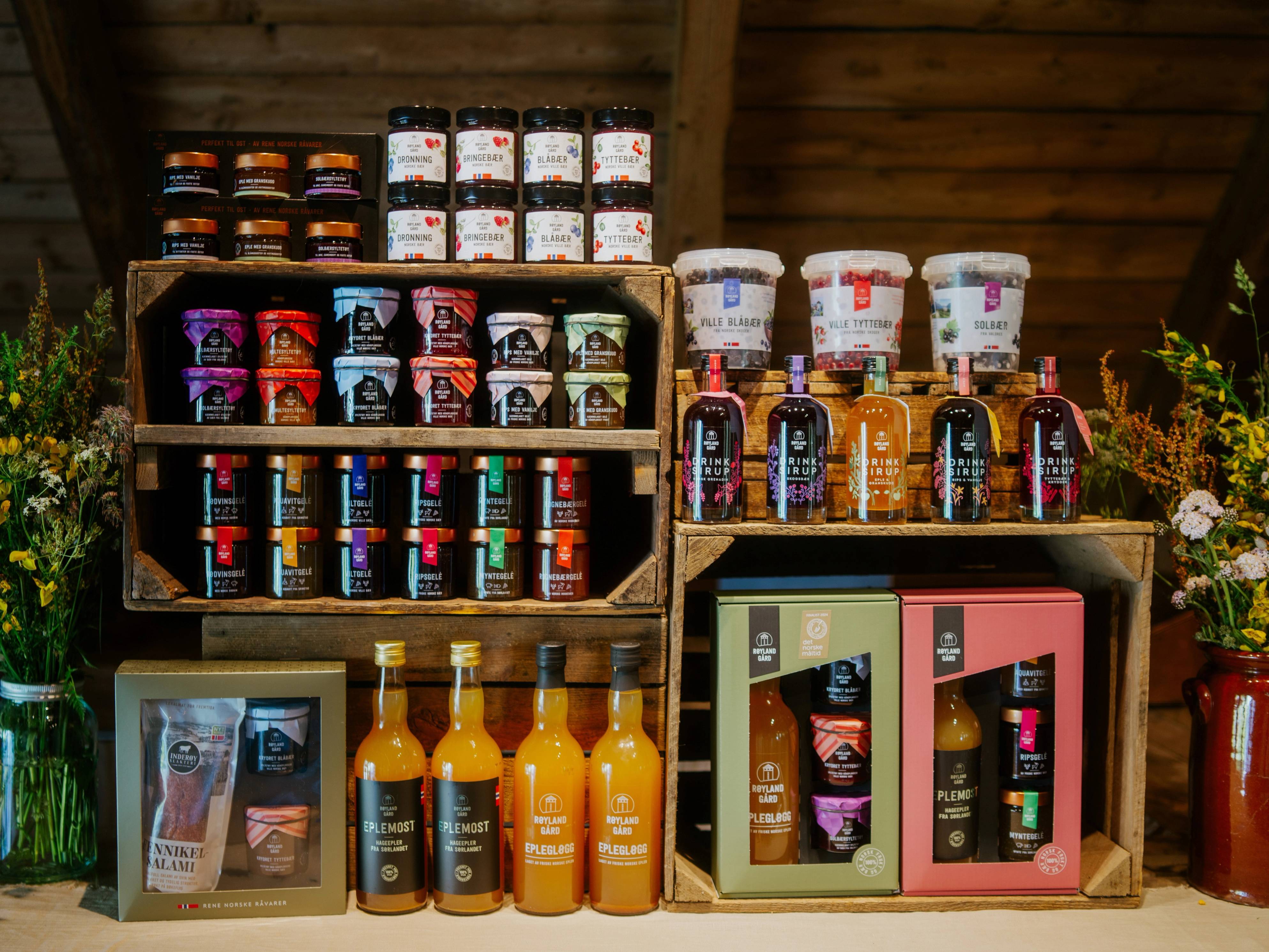 Ulike typer av helsekostprodukter og kosttilskudd på hyller i en butikk eller på et marked, med tre hyller og ulike farger på emballasjen.