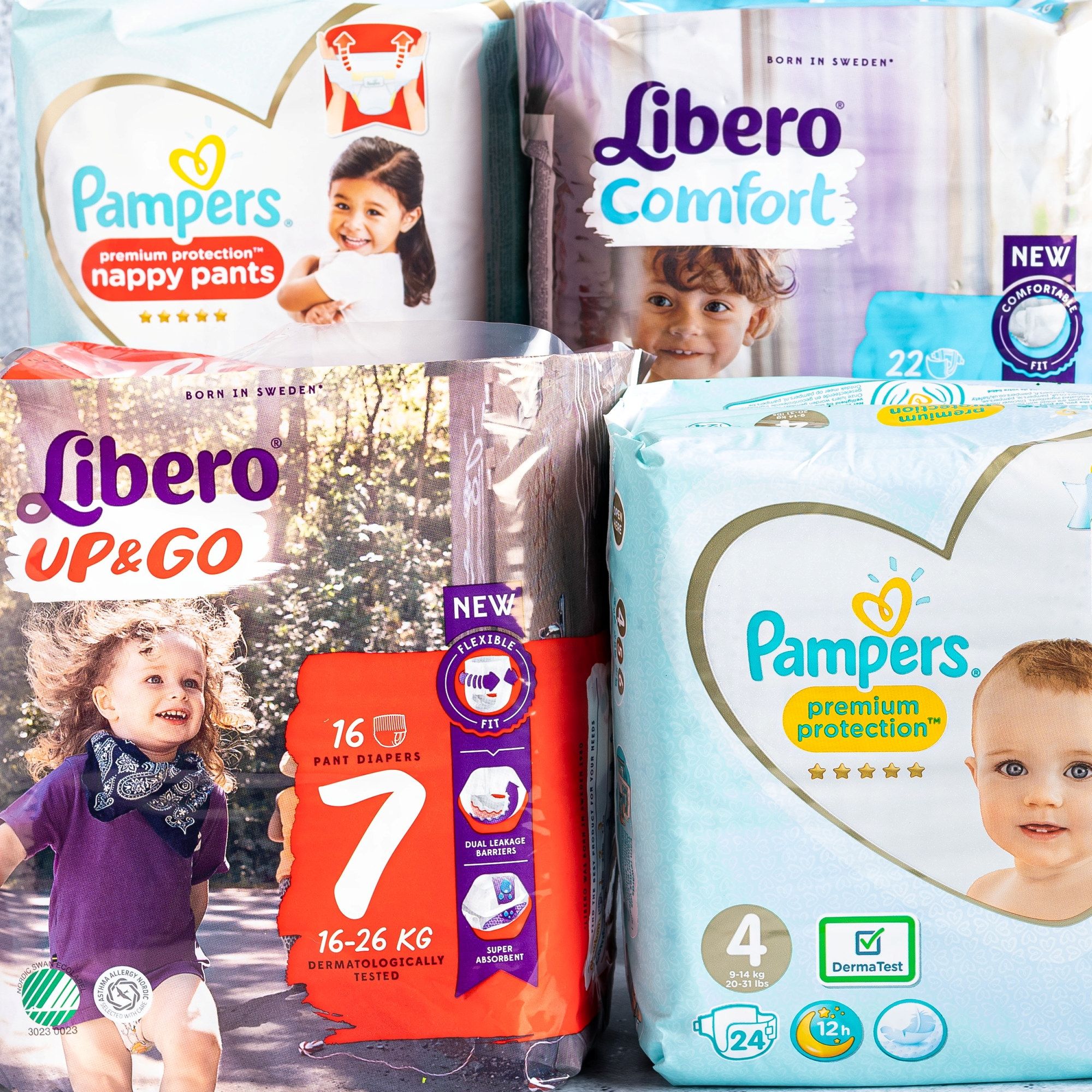 Bilde av ulike typer bleier og pakker med Pampers og Libero, plassert på en overflate.