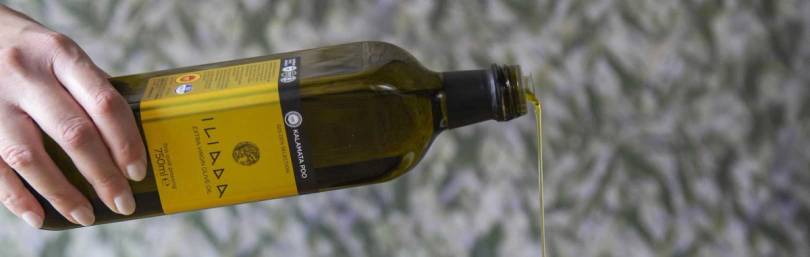 En hånd heller olje fra en flaske over en steinbakke.