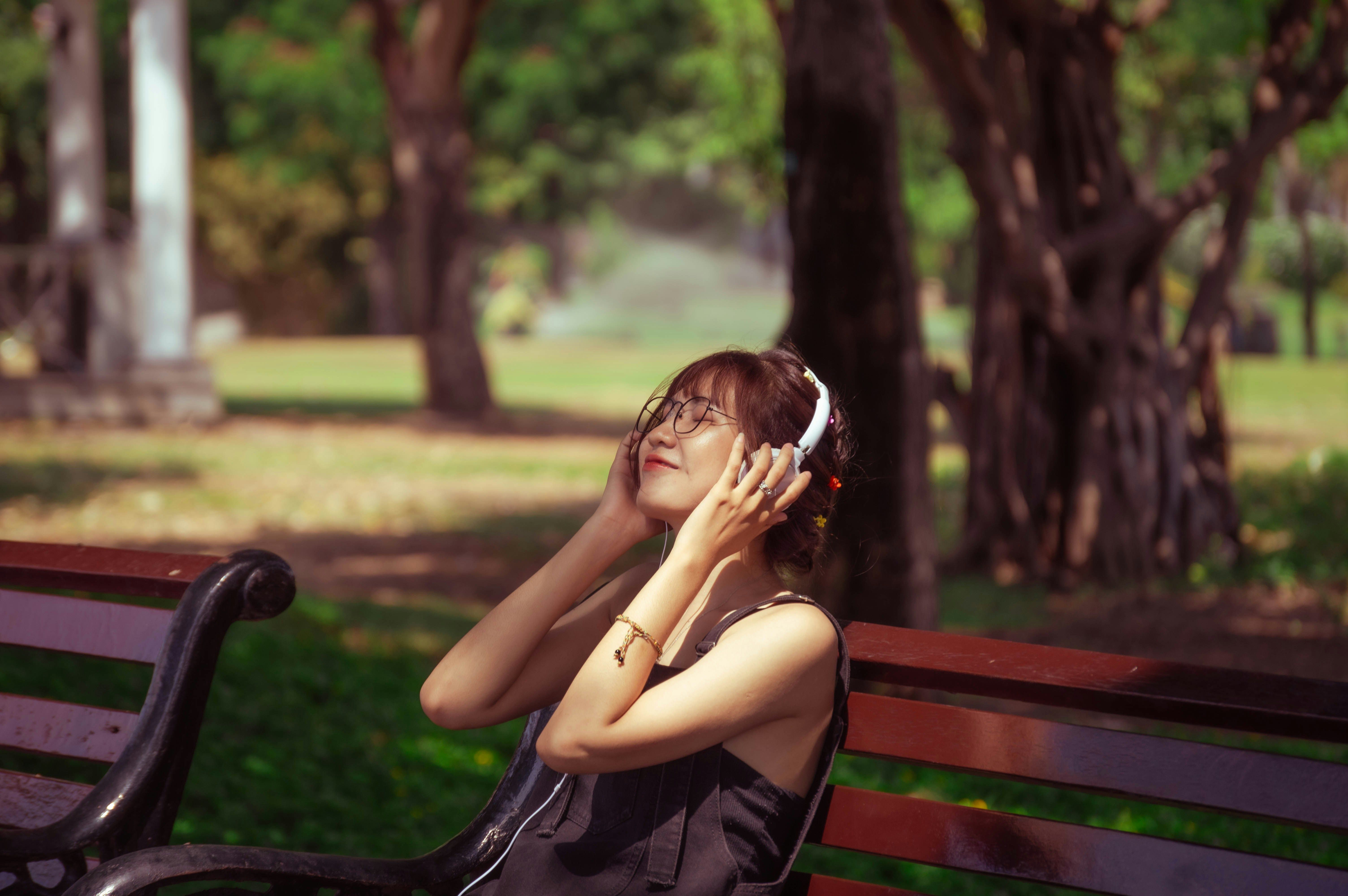 menina ouvindo música para aprender inglês no parque