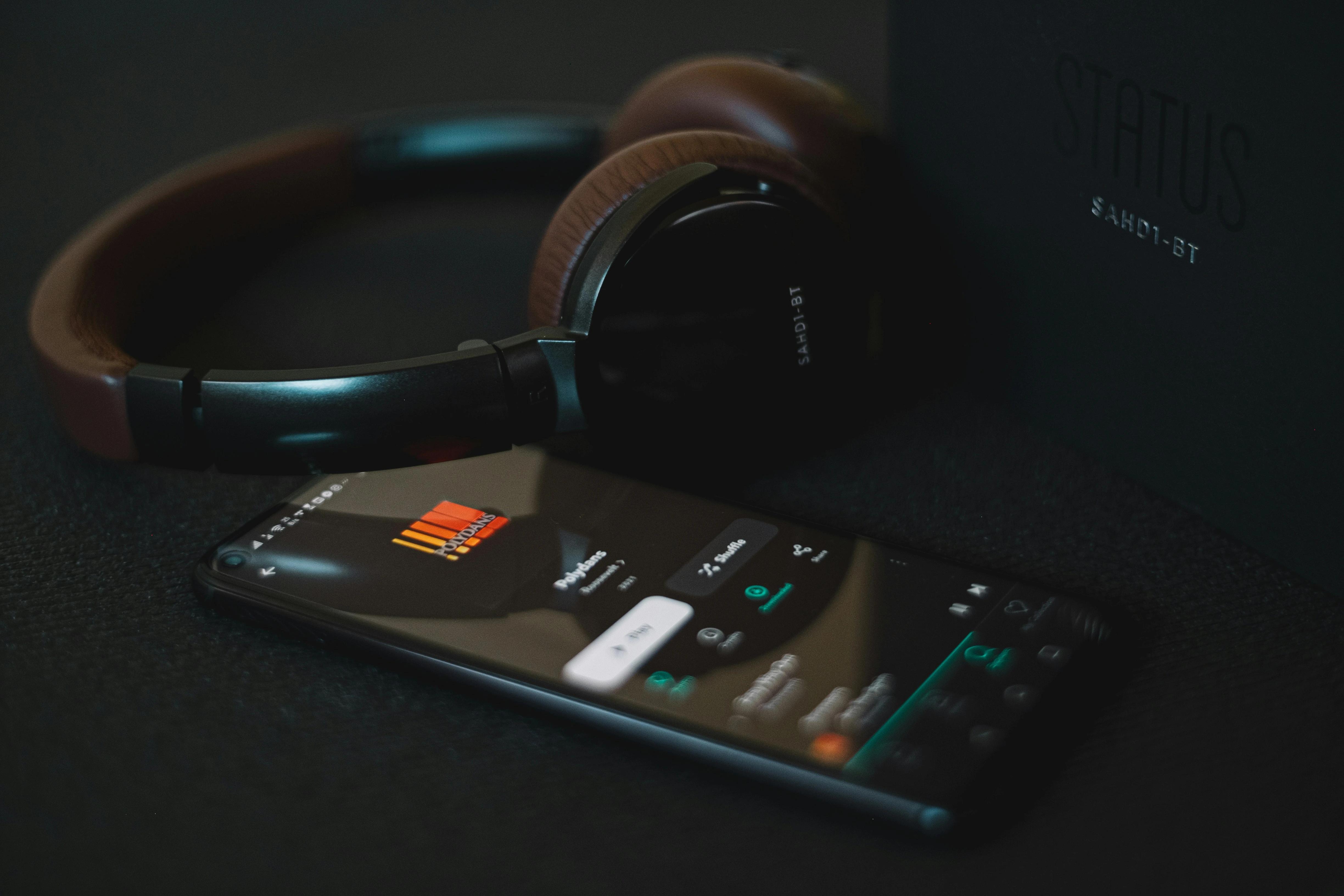 fone headset com um celular representando aplicativo para aprender inglês com música 