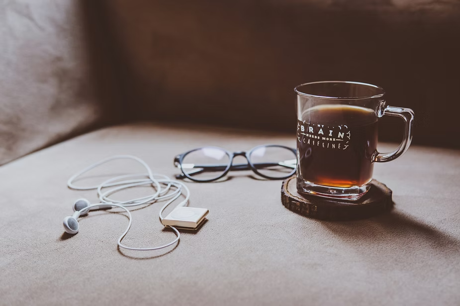 Fone, óculos e café ilustrando como é fácil e divertido aprender inglês com música