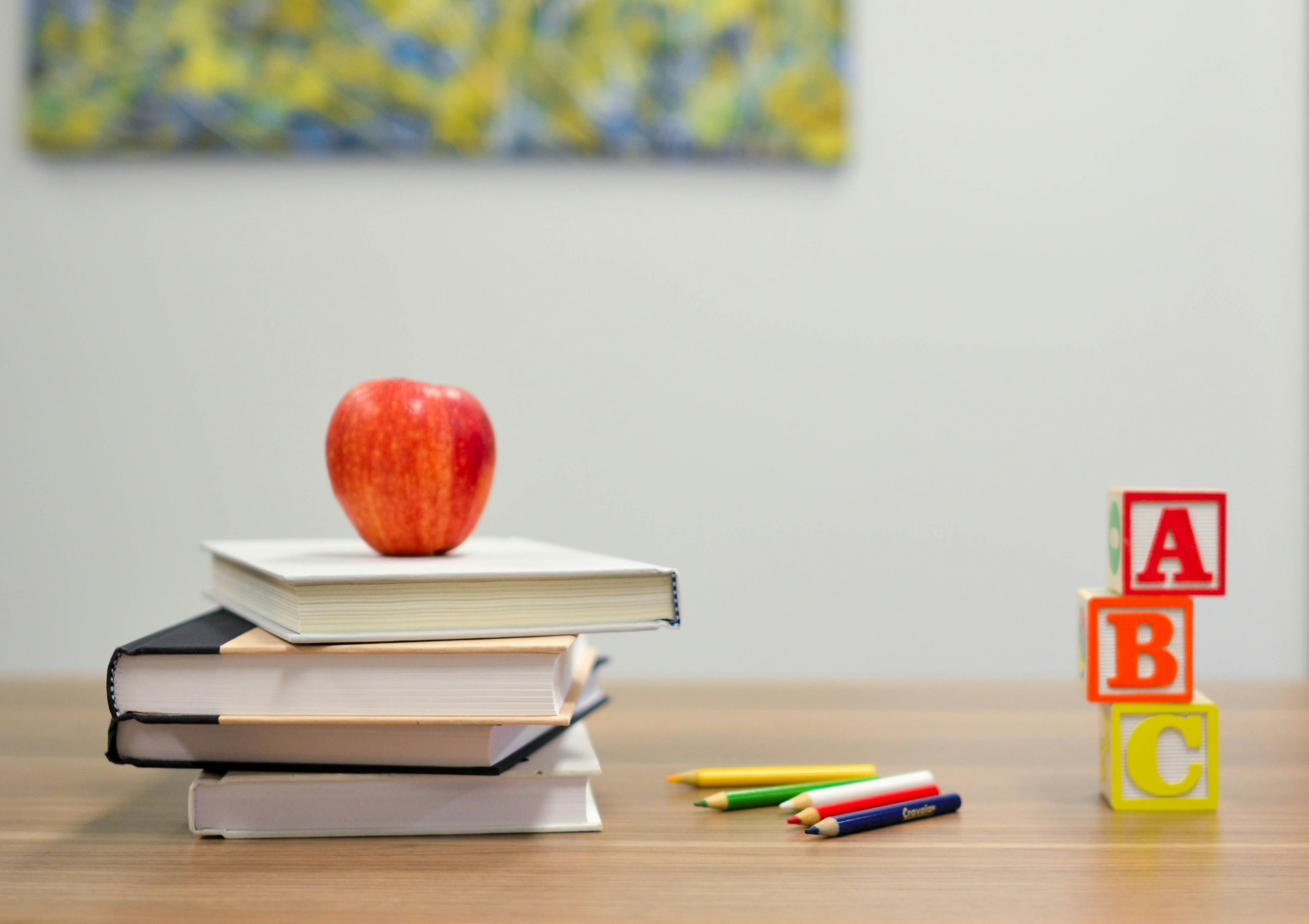 livros e maçã representando a técnica de shadow para aprender inglês com música