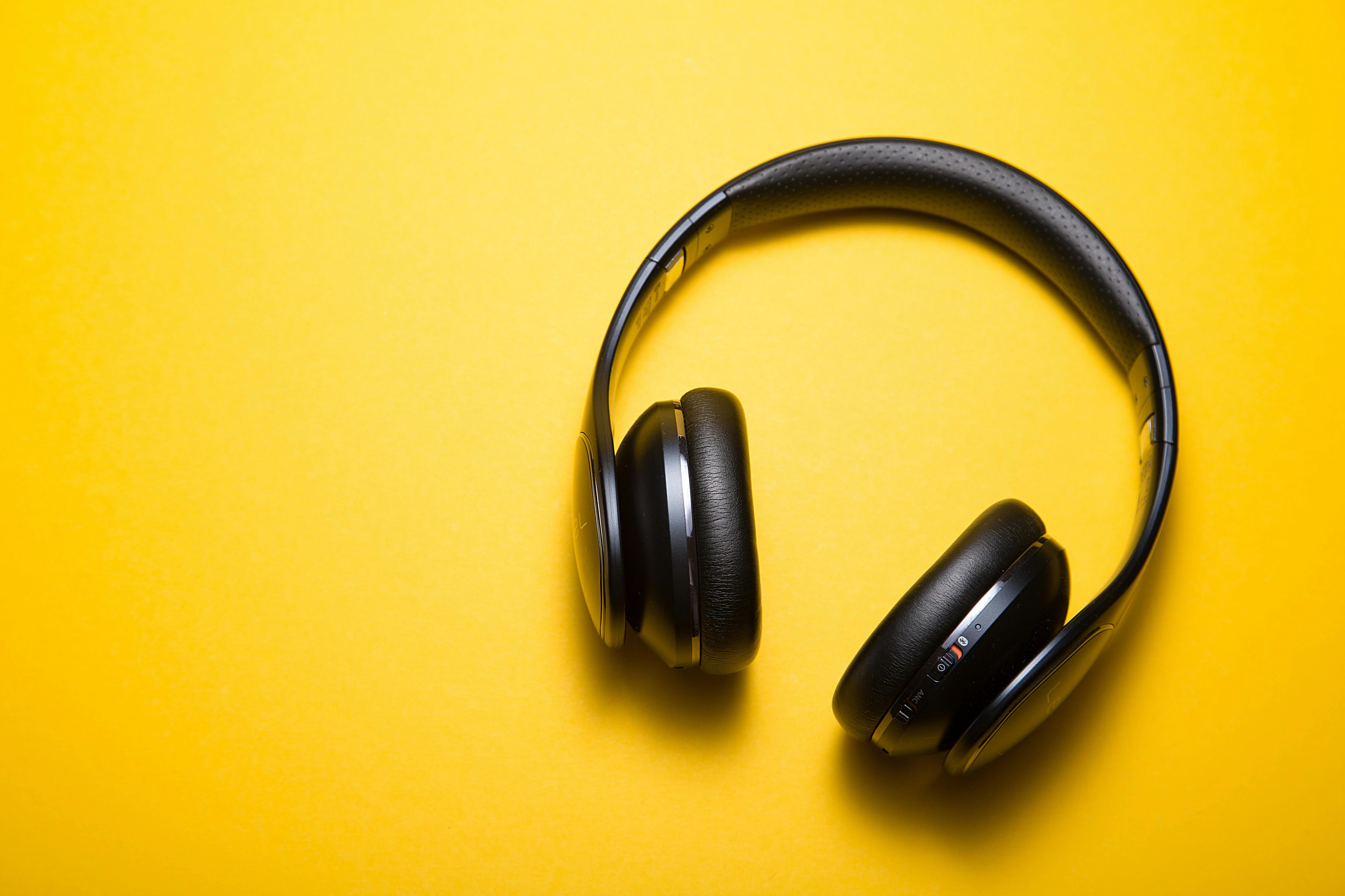 fone de ouvido com fundo amarelo representando aplicativo para aprender inglês com música 