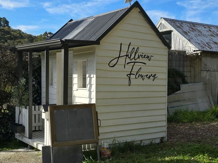 The cream weatherboard flower shed at Hillview Flowers in Mylor, the stall name hand-painted on the side