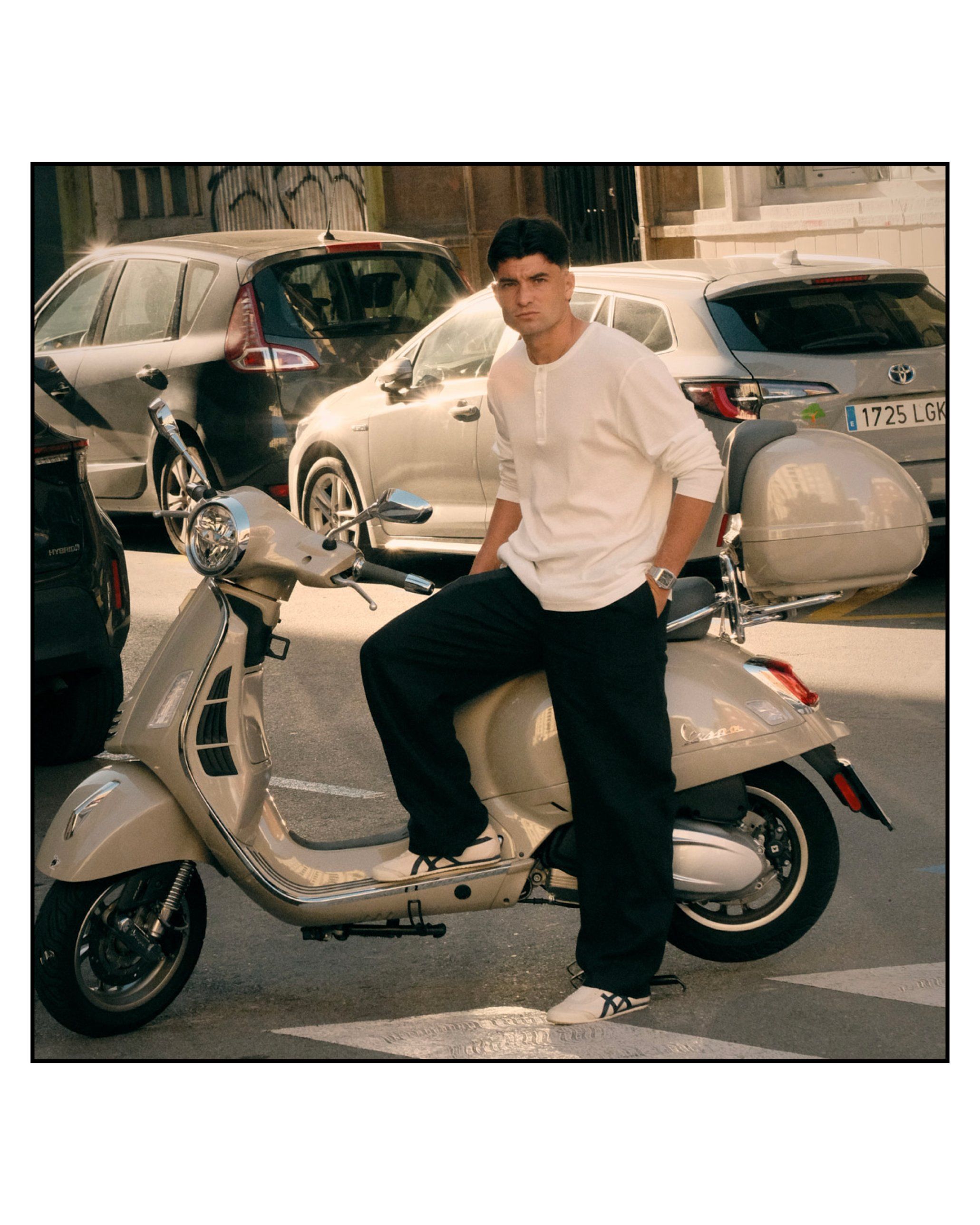 Aritz Aldasoro apoyado en una Vespa en mitad de la calle, mirando a cámara.