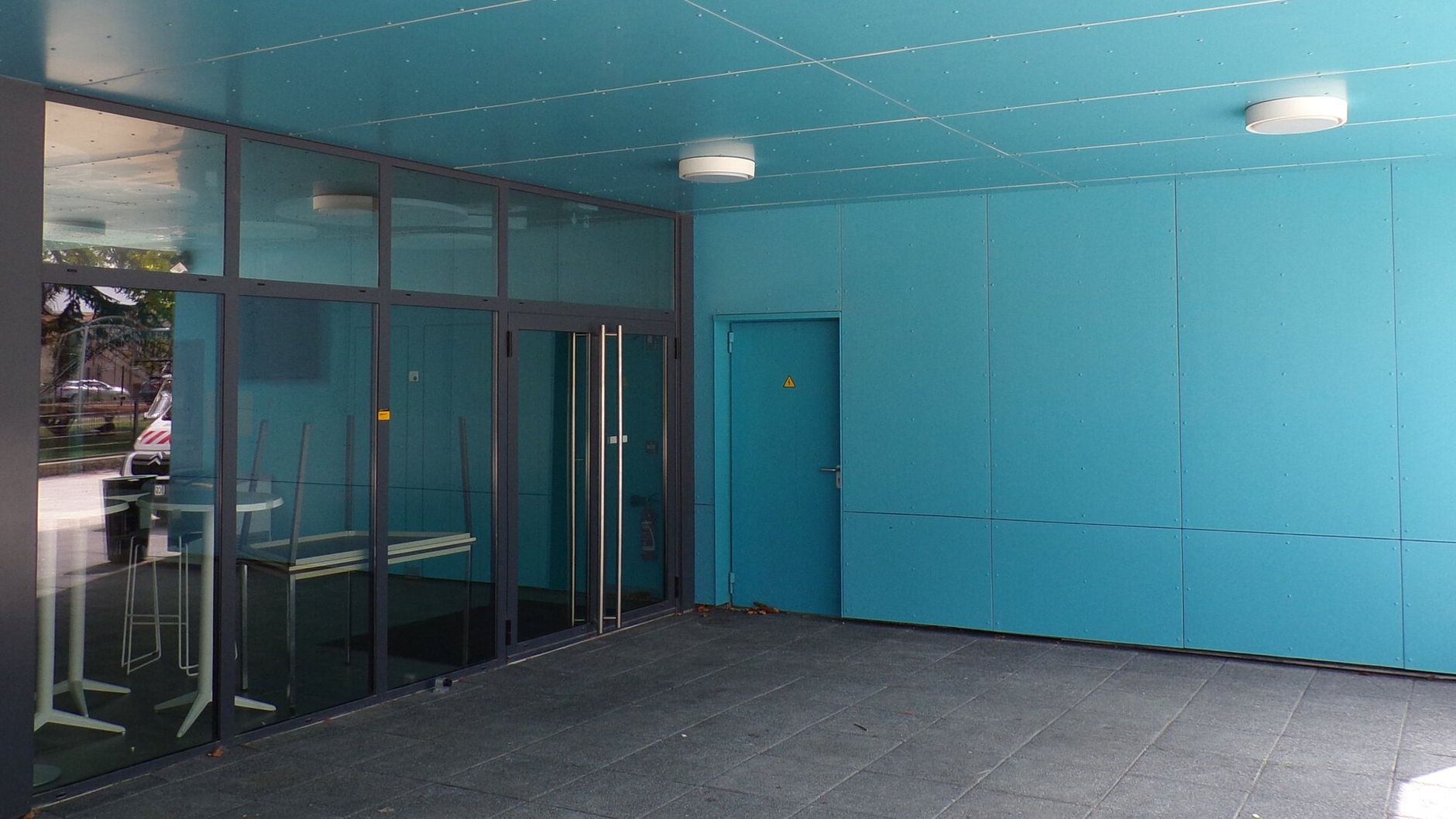 a blue building with a lot of windows and a door .