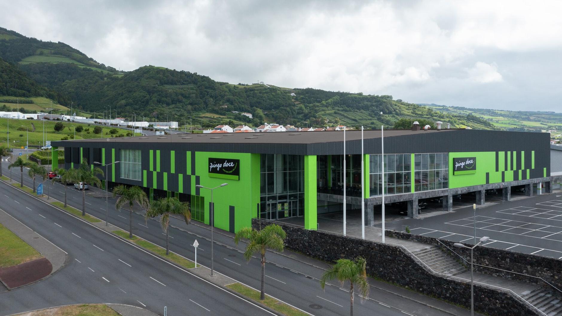 an aerial view of a large green and black building next to a road .