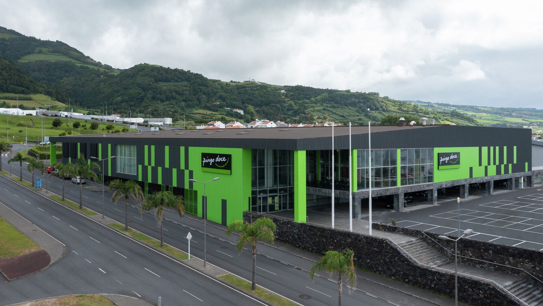an aerial view of a large green and black building next to a road .
