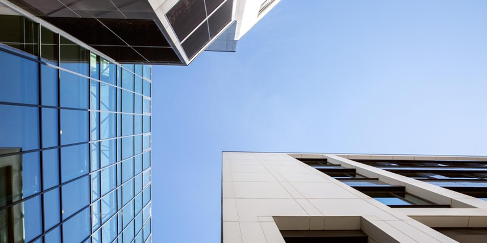 looking up at a tall building with a blue sky in the background .