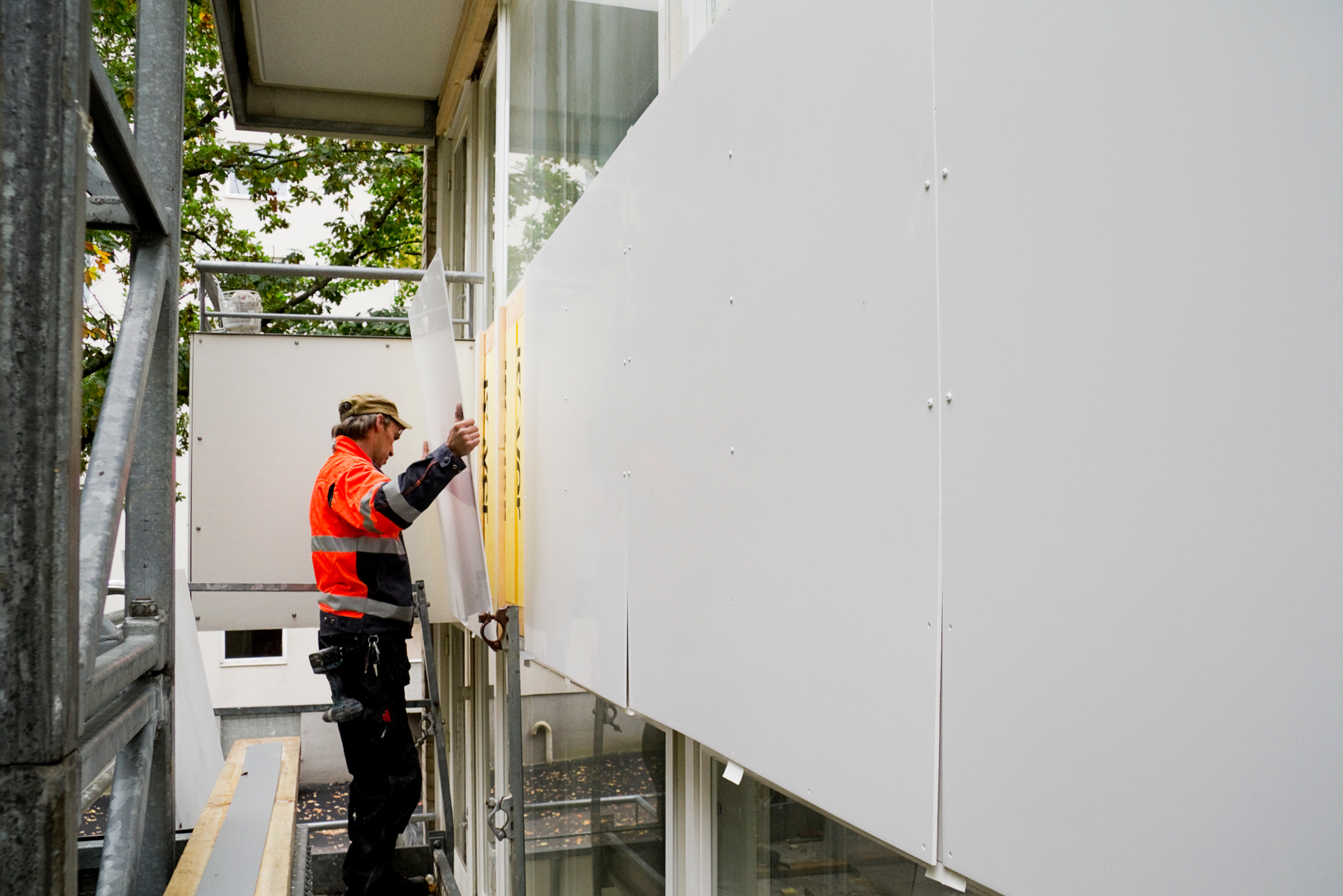 a man in an orange vest is working on a building