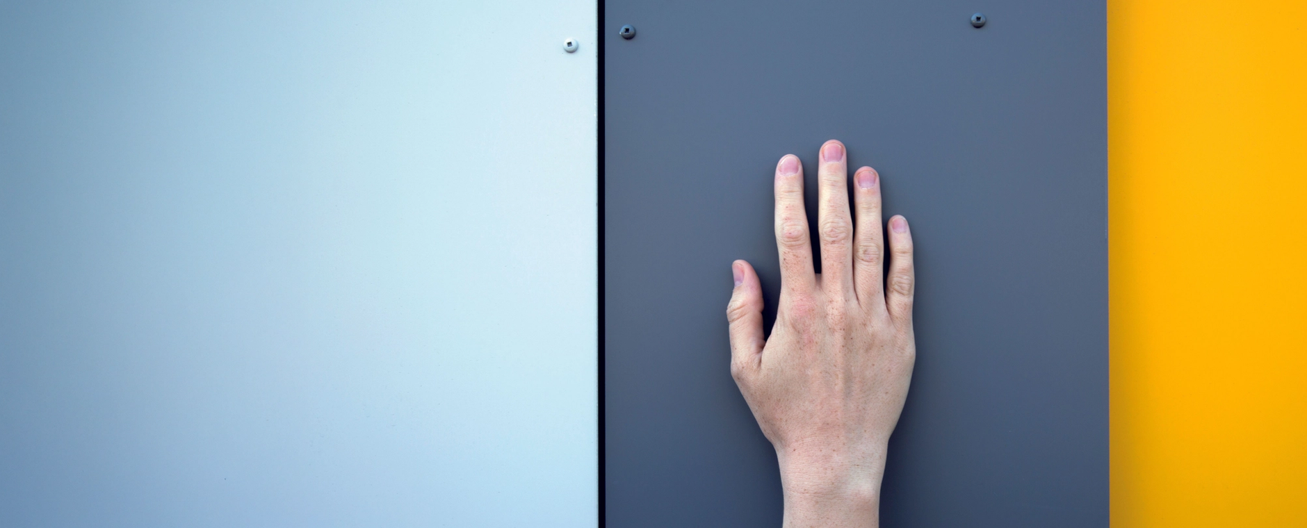 a hand is touching a blue and yellow wall