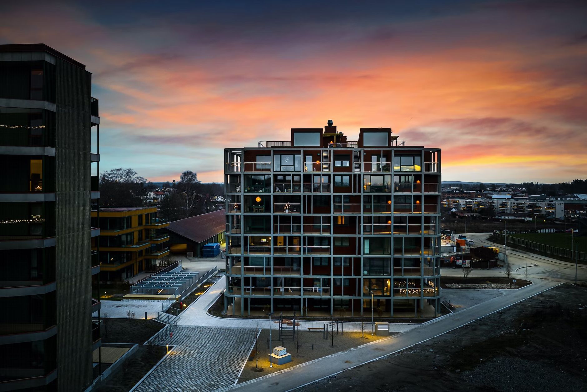 an aerial view of a large apartment building at sunset .