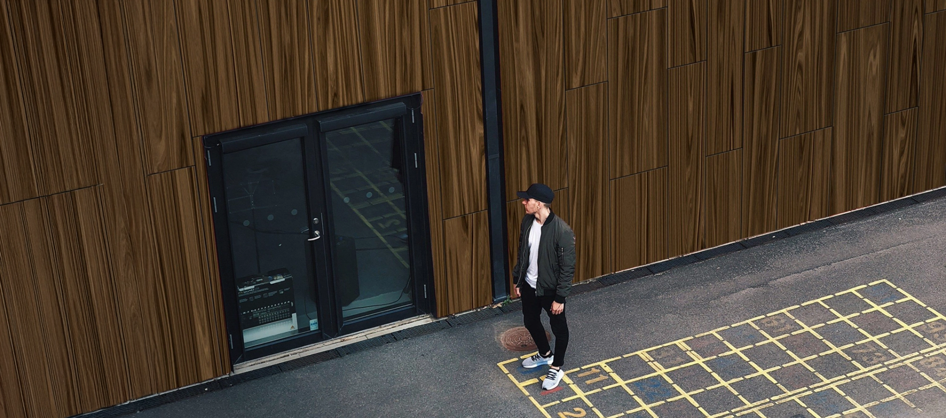 a man holding a basketball in front of a building with the number 2 on it