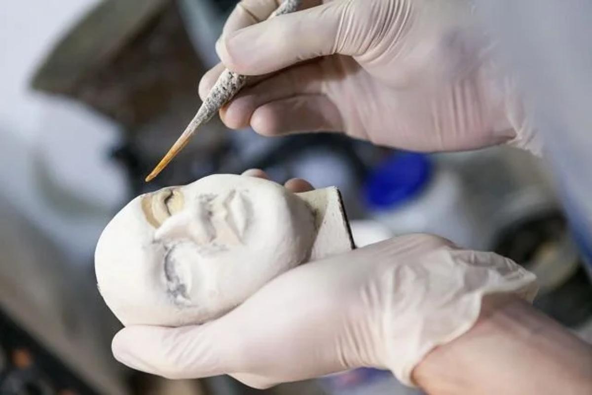 The incompressibility of time: A macro view of the meticulous, unhurried manipulation required to sculpt a face by hand, embodying the precise tactile knowledge that corporate acceleration cannot replicate or compress.