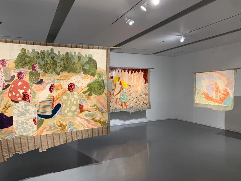 Nengi Omuku paintings installed at the Bangkok Art Biennale 2022 at JWD Art Space, showing multiple oil paintings on sanyan textile depicting collectivized figures.