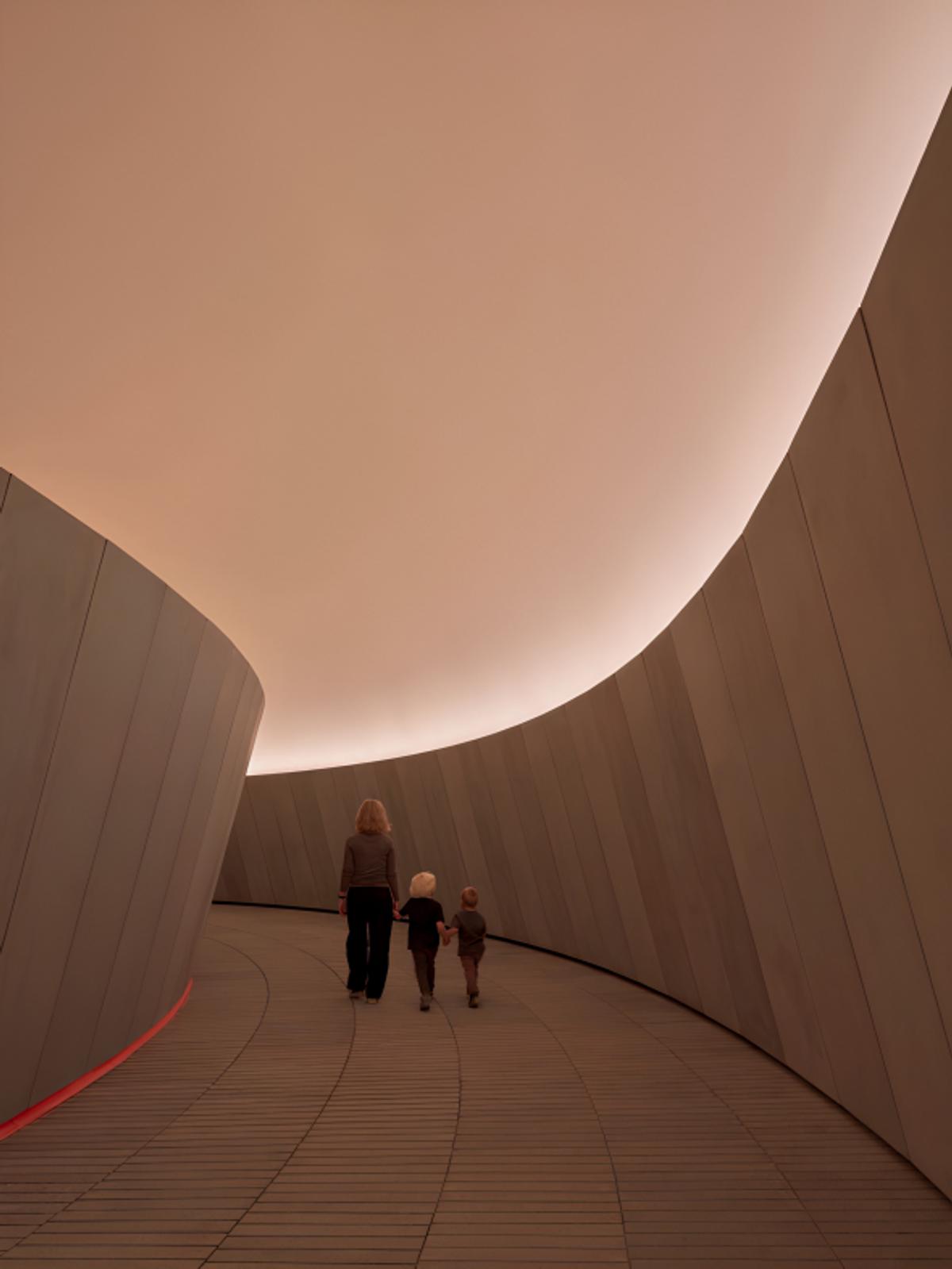 The curved subterranean approach within The Next Level expansion at ARoS Aarhus Art Museum. This architectural integration anchors the work to a fixed set of physical coordinates, securing its status as an immutable, site-specific Sovereign Object. Photograph by Adam Mørk.