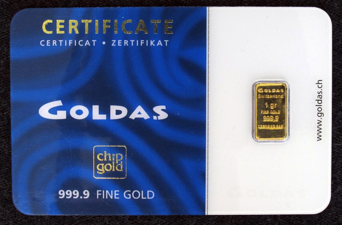 A small rectangular gold bullion bar on a plain surface.