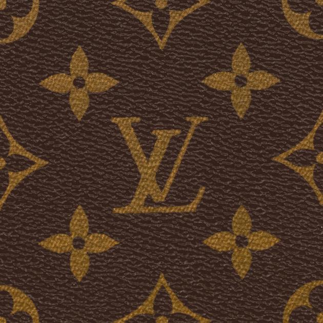 A close view of coated canvas printed with a repeating brown and gold monogram pattern of interlocking letters, quatrefoils and flowers.
