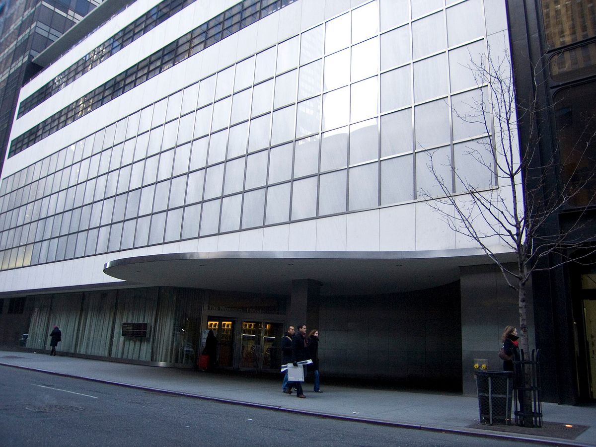 The facade of the Museum of Modern Art on West 53rd Street in Manhattan, a flat glass and stone front rising above the pavement.
