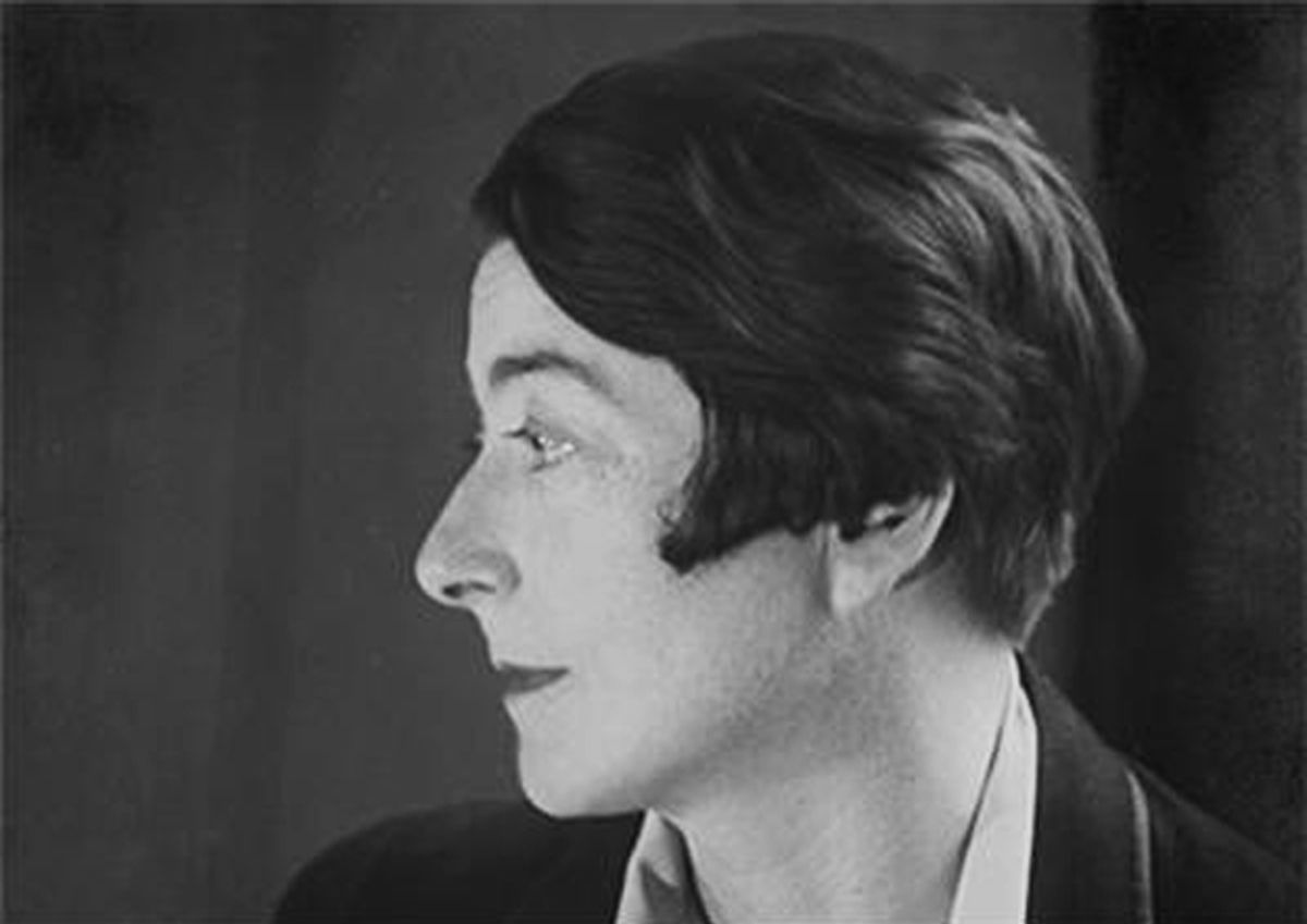 A black and white profile photograph of a woman with a dark bob, in a dark jacket with a white collar, looking to the left.