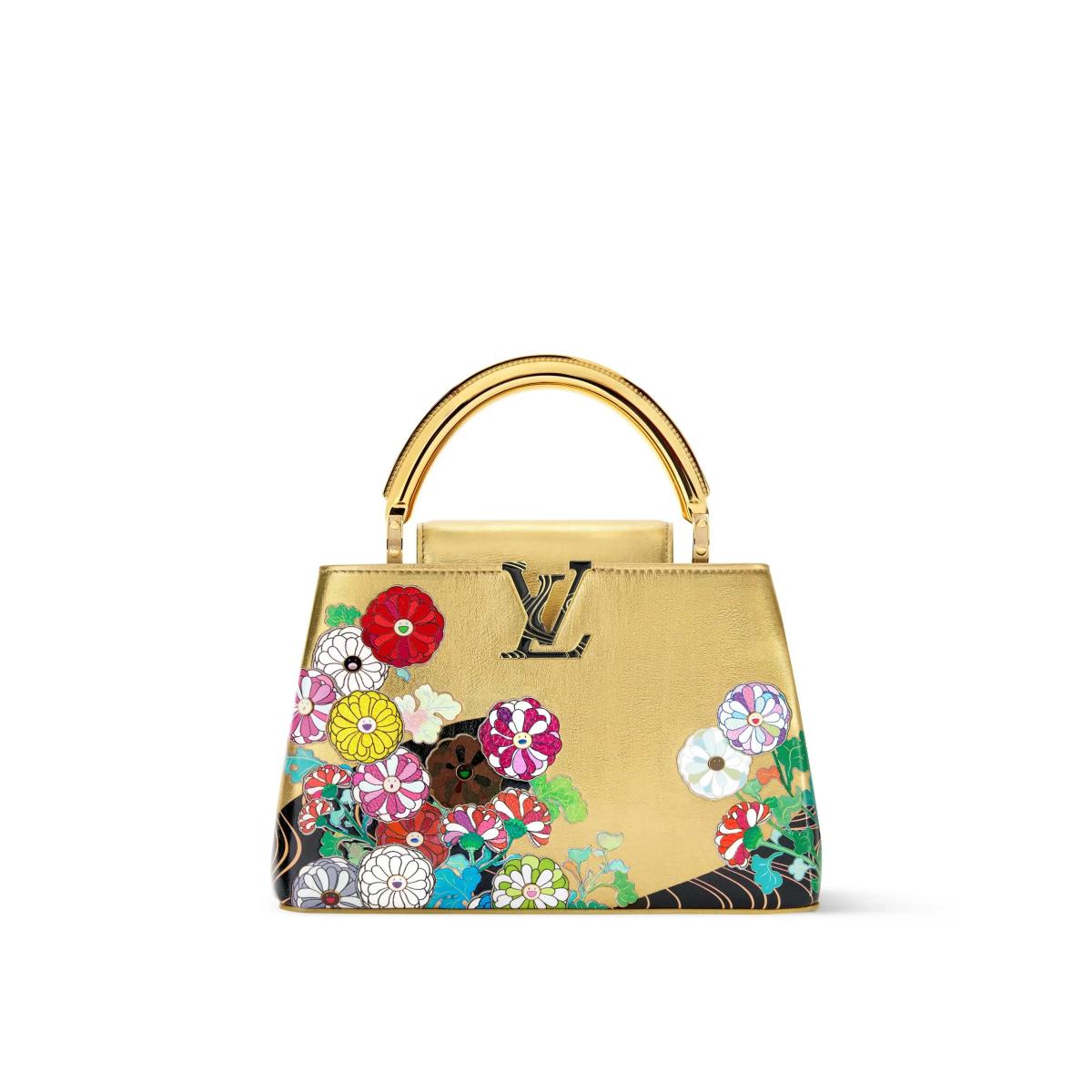 A gold leather top handle bag printed and appliqued with brightly coloured daisies, a small dark bear figure among the flowers and a gold monogram at the front.
