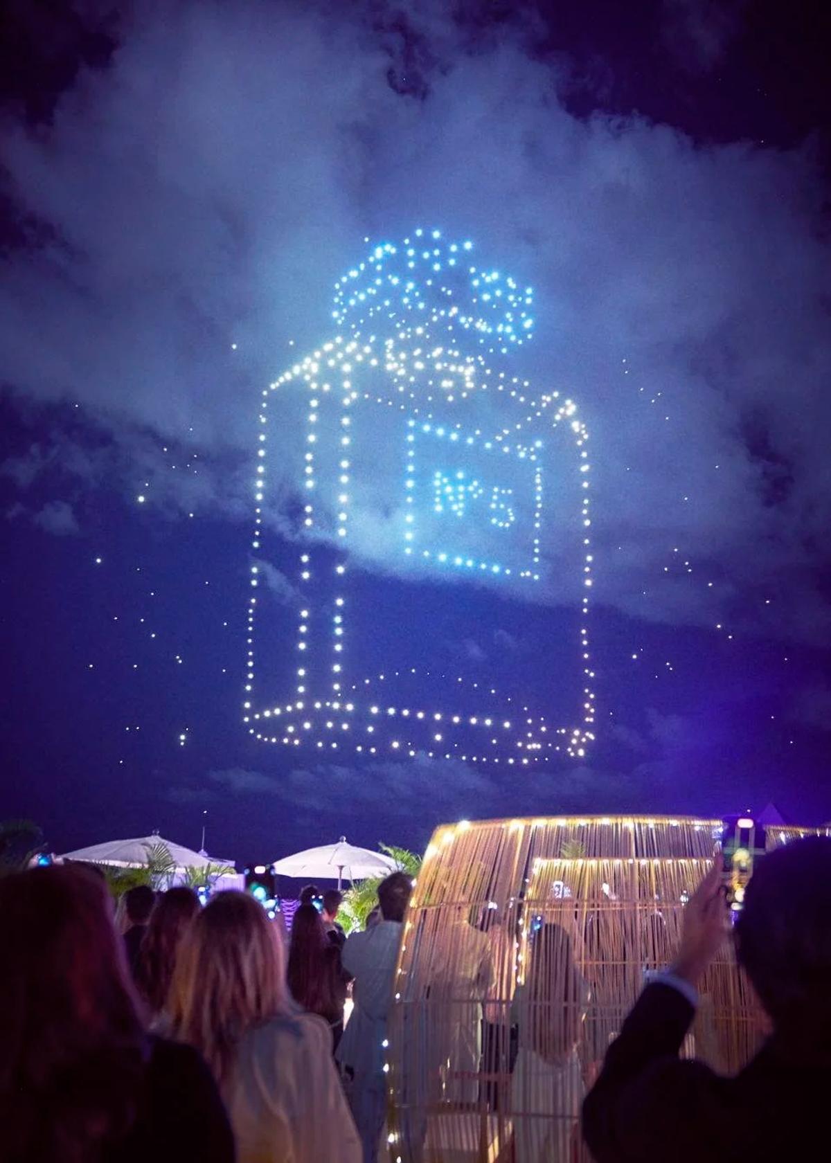 An exclusive drone light show at Art Basel Miami 2021 projects a giant Chanel N°5 bottle into the sky. This spectacle exemplifies how conglomerates attempt to restore aura by tethering products to “exclusive cultural moments” and “money-can’t-buy experiences,” treating the crisis as reputational rather than existential.