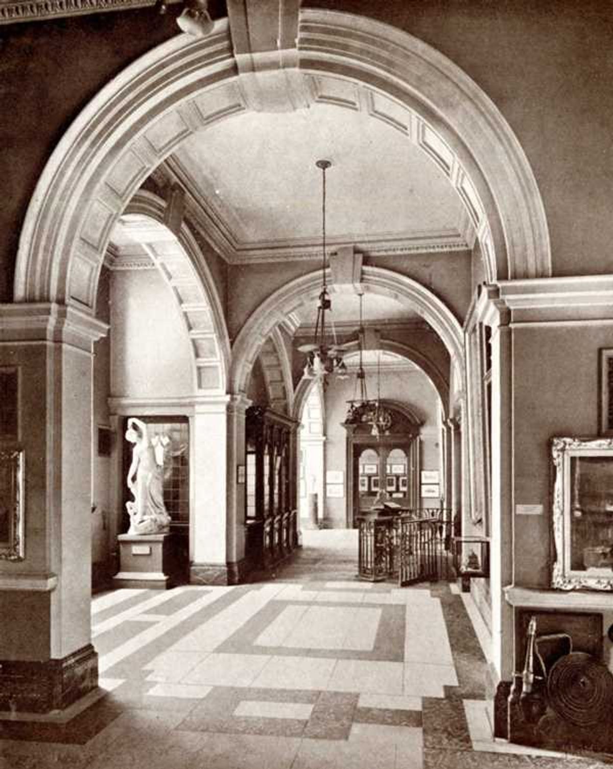 A gallery interior with works displayed along the wall.