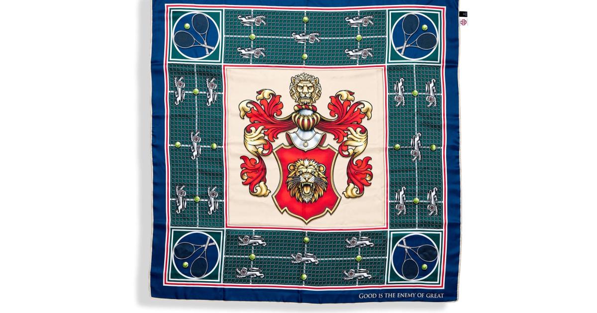 A silk scarf laid flat, its centre panel carrying a red and gold crest with two lions supporting a shield, framed by a green ground and a navy border with small motifs.