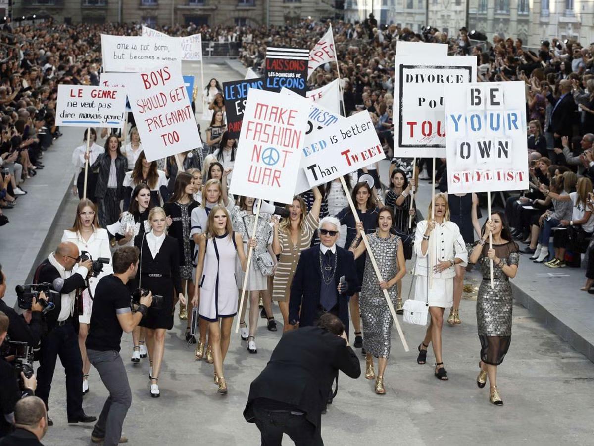 The 'indiscriminate maw' of enterprise culture: Chanel's Spring/Summer 2015 finale, where models staged a faux protest. This event exemplifies the neutralization of political dissent, transforming the visual language of activism into a consumable, depoliticized style. 