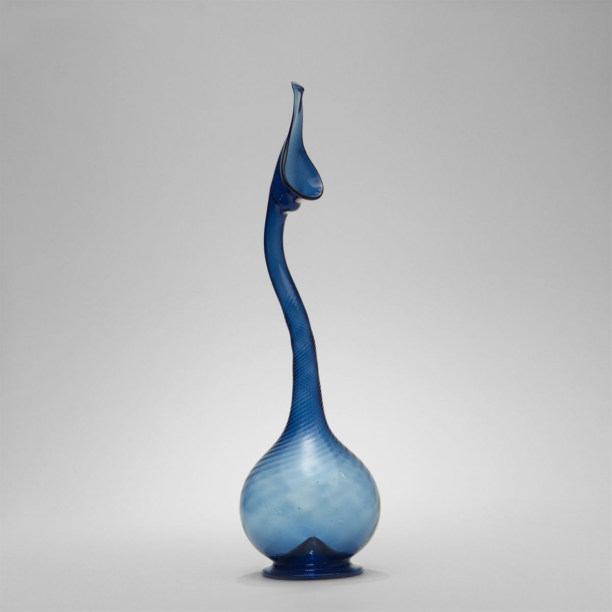 A nineteenth-century glass bottle with a long curved neck, photographed against a plain ground.