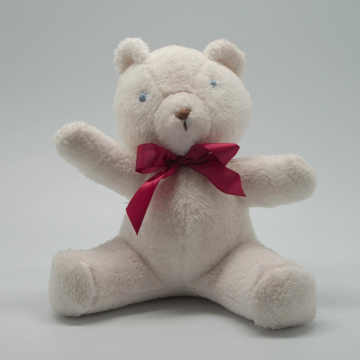 A handmade teddy bear with stitched features, photographed against a plain ground.