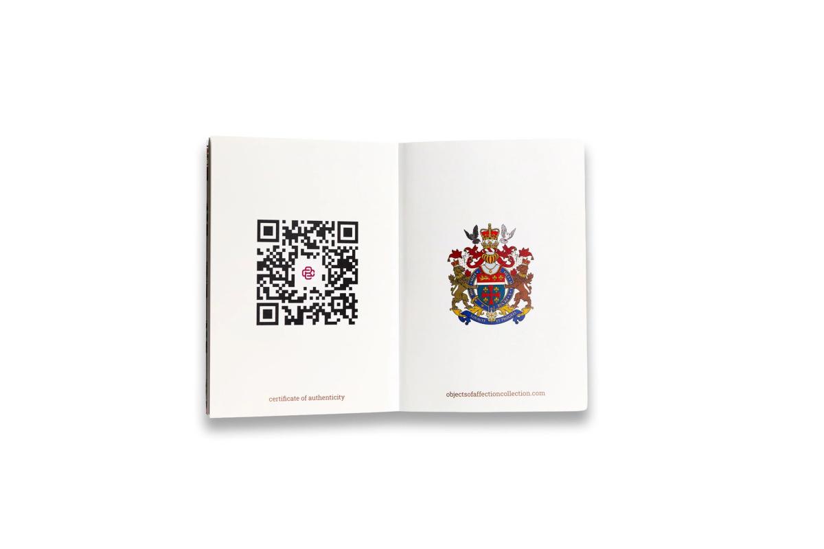 A slim certificate booklet opened flat, a QR code printed on the left page and the lion crest on the right.