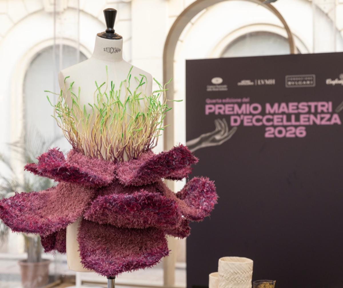 The institutional lens: An artisan artifact staged beside the corporate infrastructure of the Premio Maestri d’Eccellenza 2026, illustrating the precise intersection where material labor meets brand narrative.
