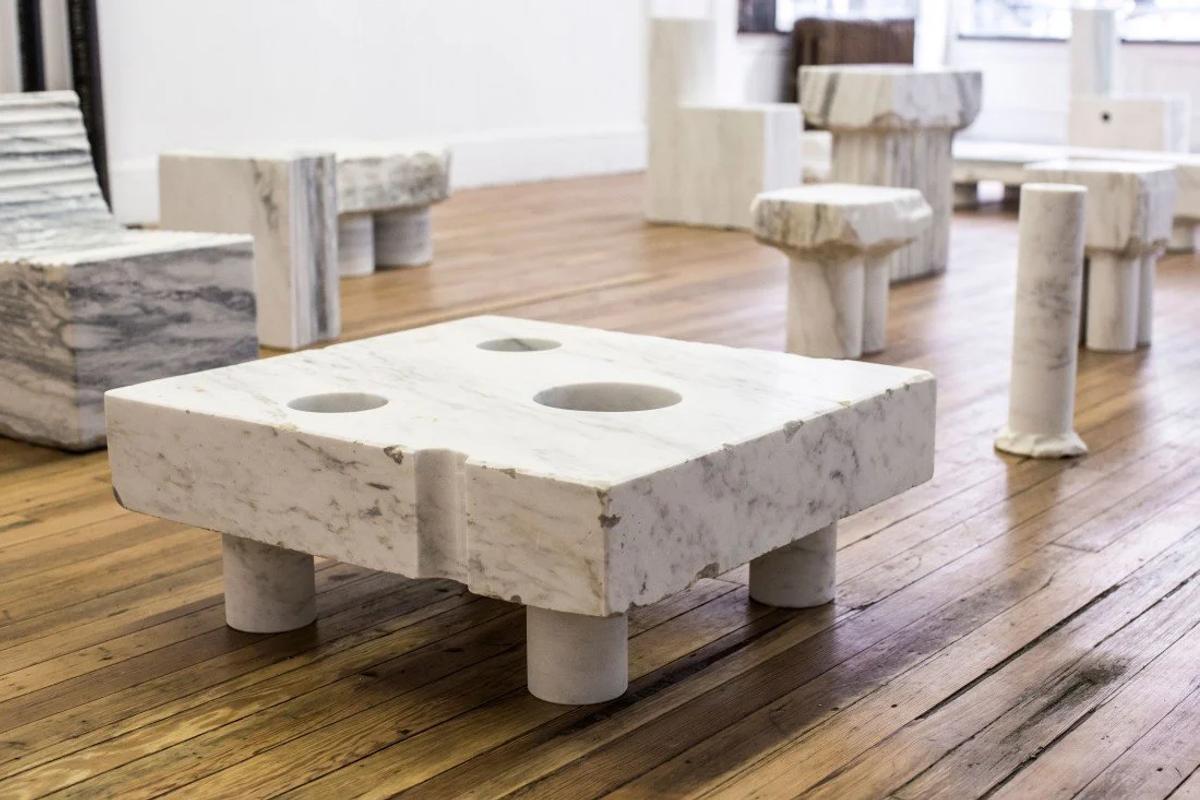 The Ethics of Weight: An exhibition layout featuring the marble works showcased, where the contrast between raw, rough-hewn quarry edges and polished functional surfaces reveals the material's geological narrative.