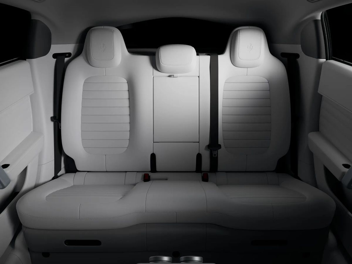 The rear bench of the Ferrari Luce in pale Perla leather, shown square on, with two sculpted outer seats and a centre position between them.
