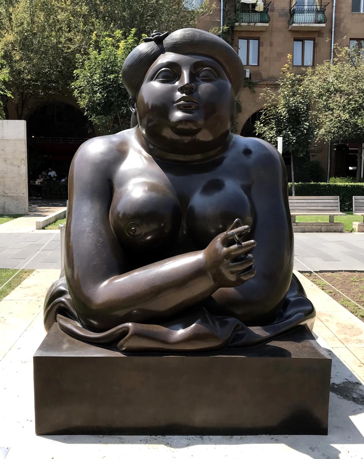 Fernando Botero's Smoking Woman, a monumental bronze sculpture depicting a seated woman in his characteristic voluminous style
