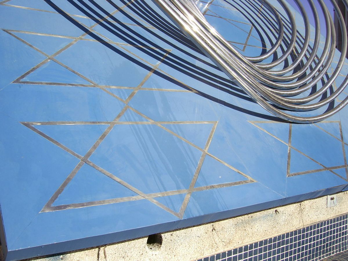 Detail of the Star of the Knesset by Yaacov Agam at the Israeli Parliament in Jerusalem, showing a Star of David on a blue mirrored surface with the kinetic steel ring structure above