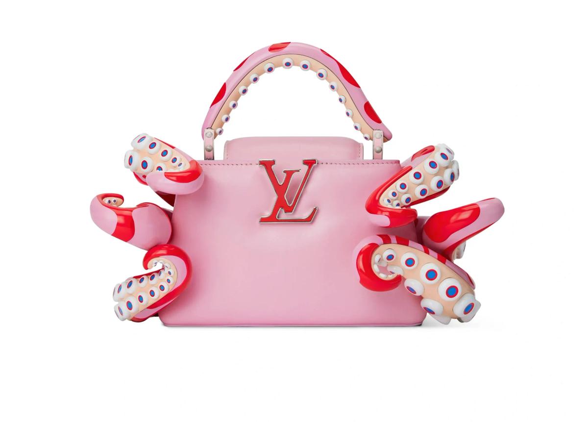 A pink structured handbag with a raised monogram, wrapped by moulded red and white spotted tentacle forms curling over its sides and handle.