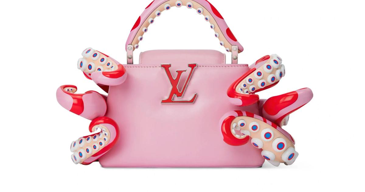 A pink leather handbag with a monogram clasp, wrapped by moulded red and white spotted tentacle forms curling around its sides and handle.