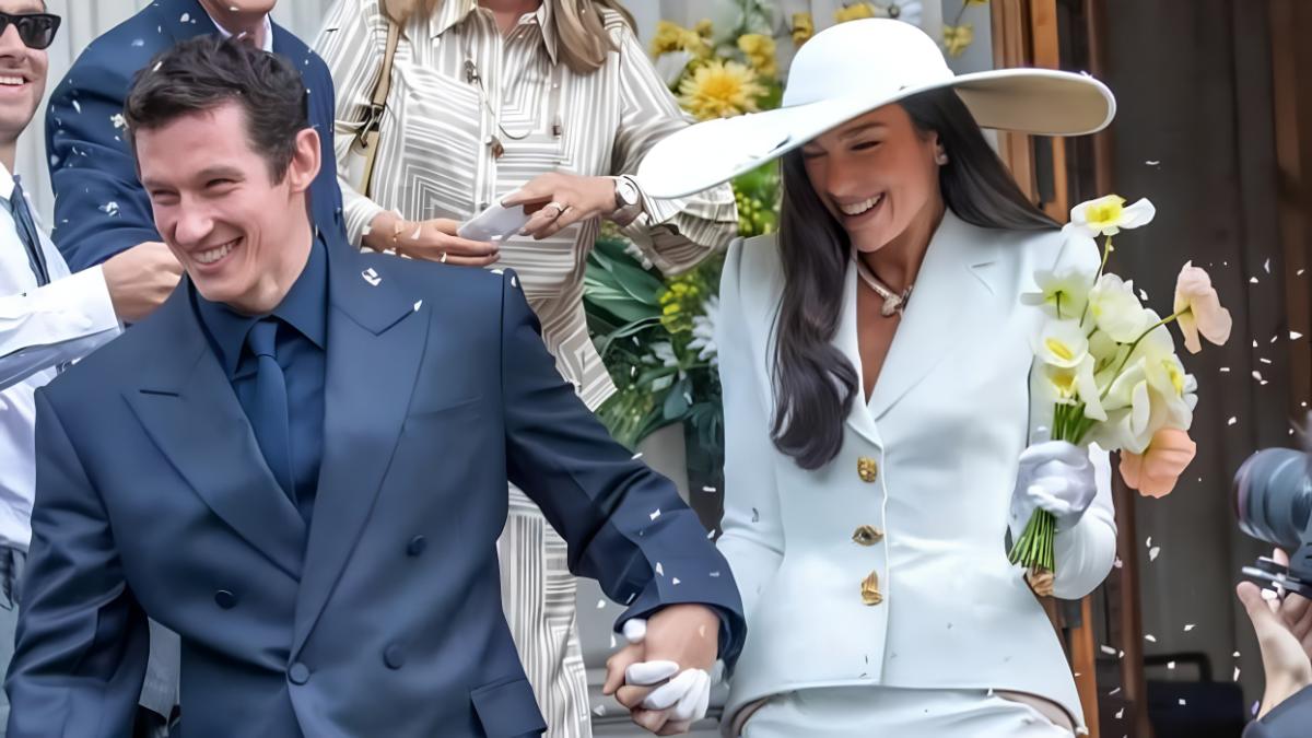 Dua Lipa in custom Schiaparelli Haute Couture by Daniel Roseberry at Old Marylebone Town Hall, May 31, 2026. The material composition of ivory cady and personalized anthropomorphic hardware shifts the object from standard bridal attire into a Material Singularity.