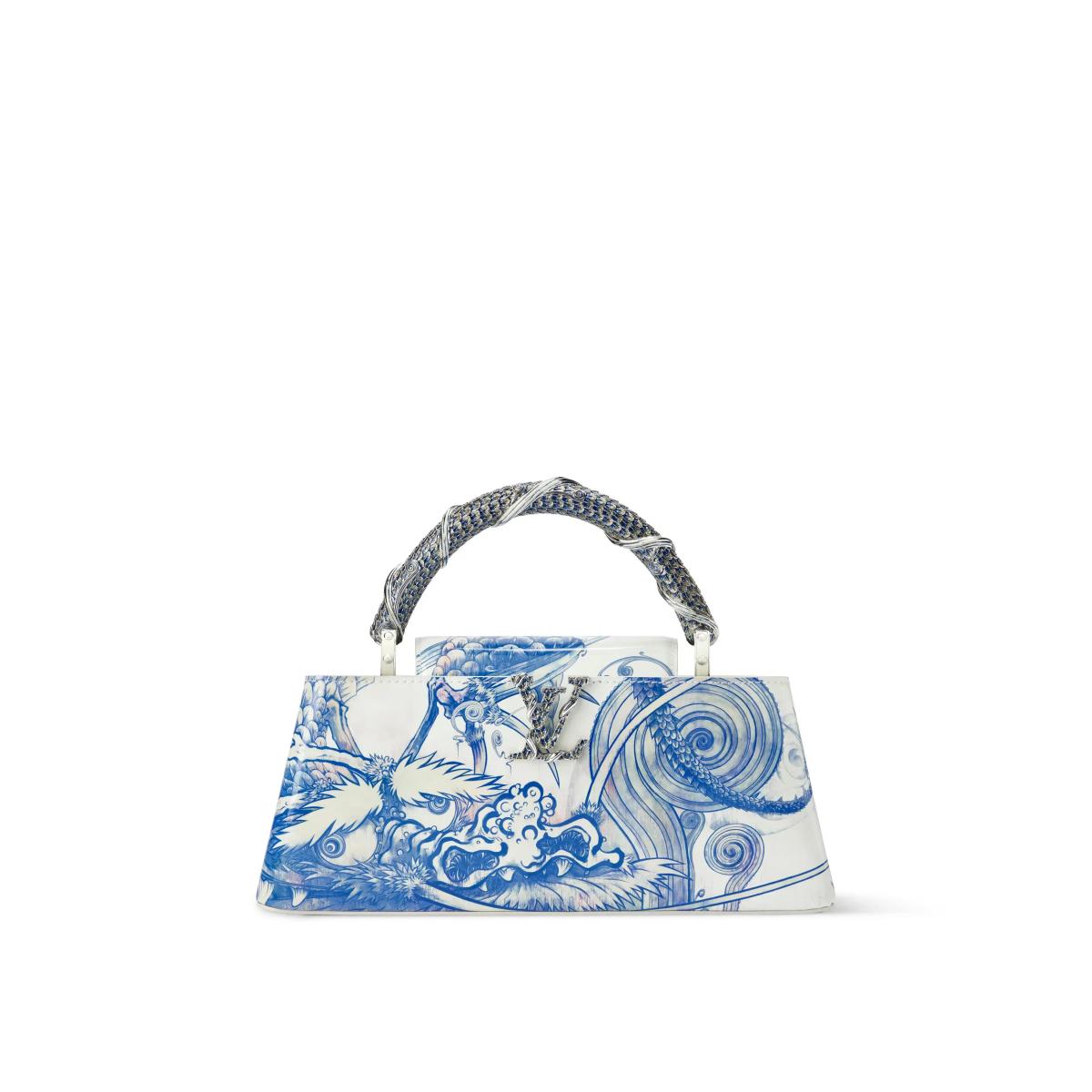 A white handbag painted in blue with a dragon among stylised waves in the manner of blue and white porcelain, with a scaled blue and white top handle.