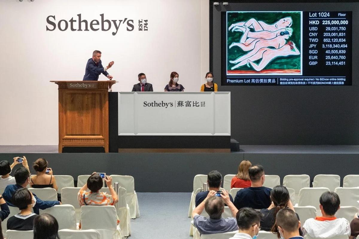  Much like the luxury market, the contemporary art market, seen here in a high-stakes auction, operates on a speculative logic where value is driven by 'collective belief' and inflated prices, often leading to a 'narrative breakdown' where meaning declines as numbers soar. 