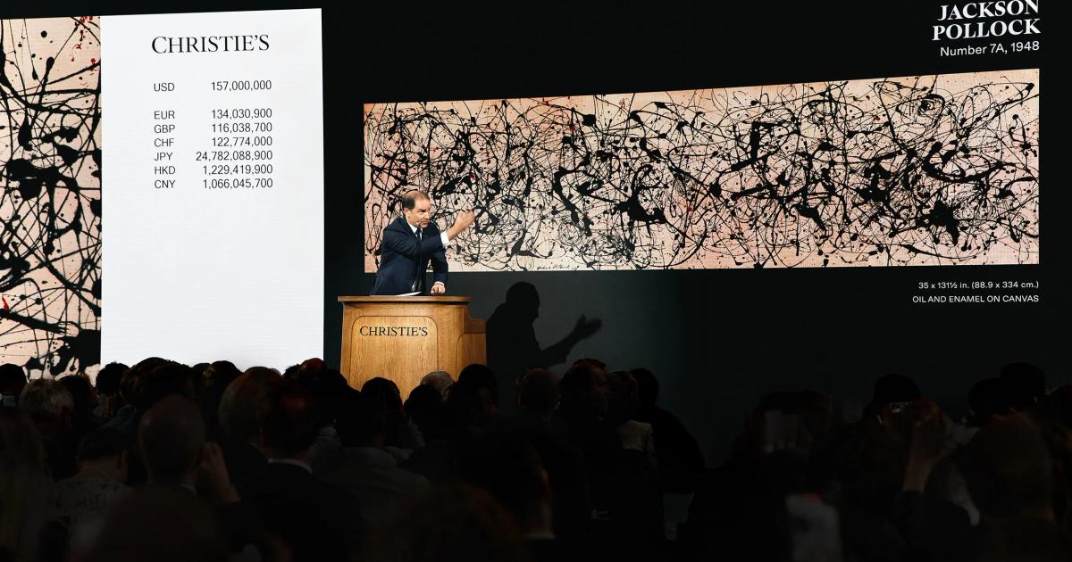 An auction room at Christie's, the auctioneer at a lit rostrum before a wide screen showing a Jackson Pollock drip painting and a column of bids in several currencies, an audience seated in darkness.