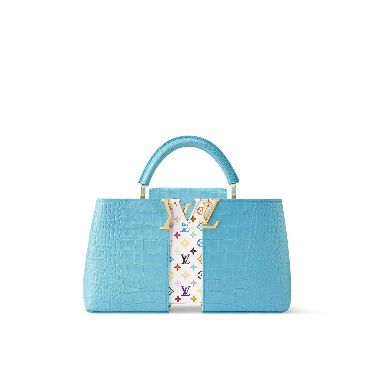 A pale blue crocodile skin top handle bag with a wide vertical panel of white and multicoloured monogram print running down the centre.